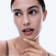 OGB Stardust Elixir After Glow: model met een stralende glow en haar hand onder haar kin