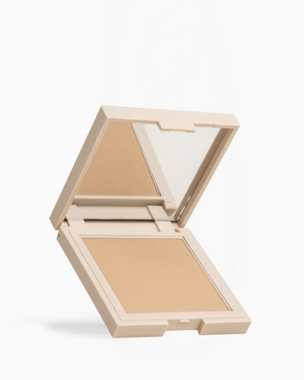 Airbrush Bronzer | Fair An open square makeup compact with a mirror on the inside of the lid and a pressed powder pan in a warm beige shade, shown on a clean white background.