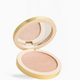 An open round makeup compact with a gold-tone case, showing a shimmering light peach-beige pressed powder and a mirror on the inside of the lid, set against a clean white background.