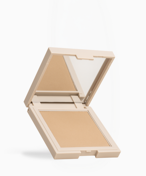 An open square makeup compact with a mirror on the inside of the lid and a pressed powder pan in a warm beige shade, shown on a clean white background.