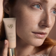 OGB Miracle Skin Tint Fair: model met rood haar houdt de skin tint vast