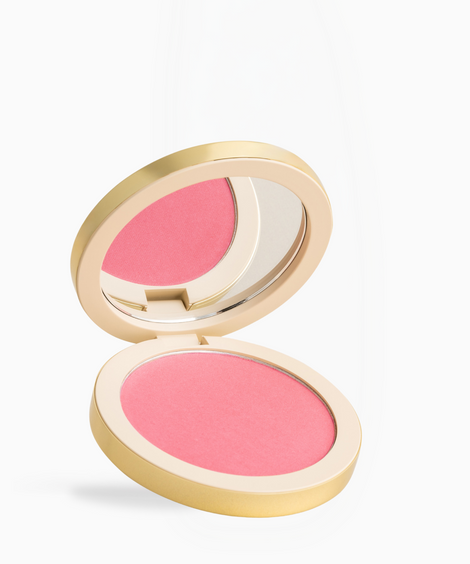 An open round blush compact with a gold-toned case, showing a vibrant pink pressed powder blush and an integrated mirror, set against a clean white background.