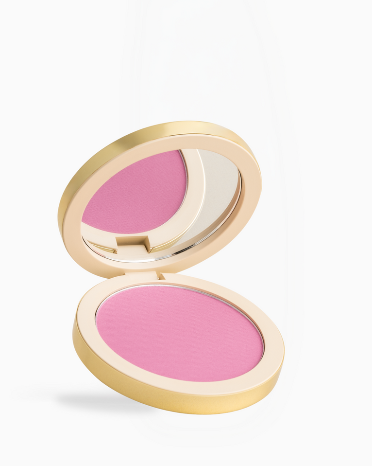 An open round makeup compact with a gold-toned case, showing a bright pink pressed powder and a mirror on a clean white background.